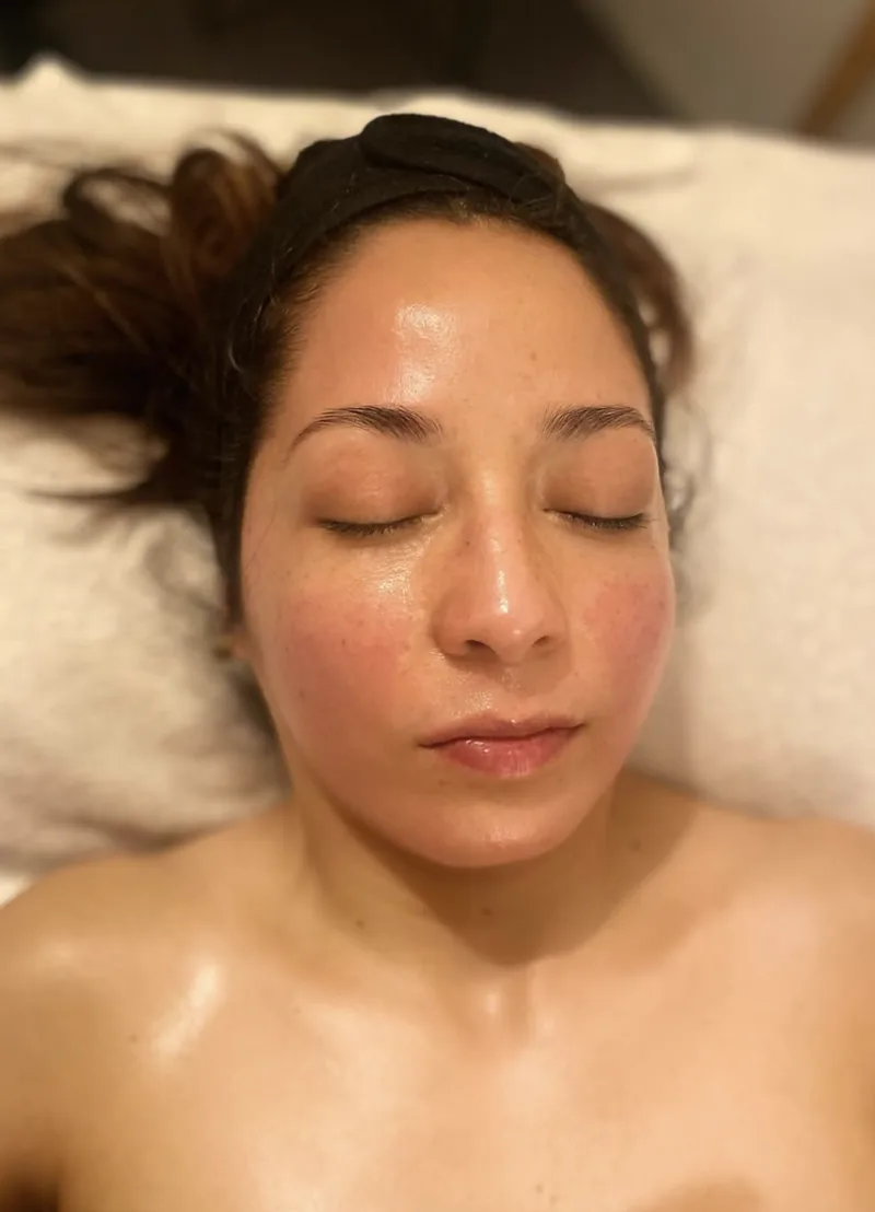 Le visage lumineux d’une cliente allongée, les yeux fermés, juste après son soin